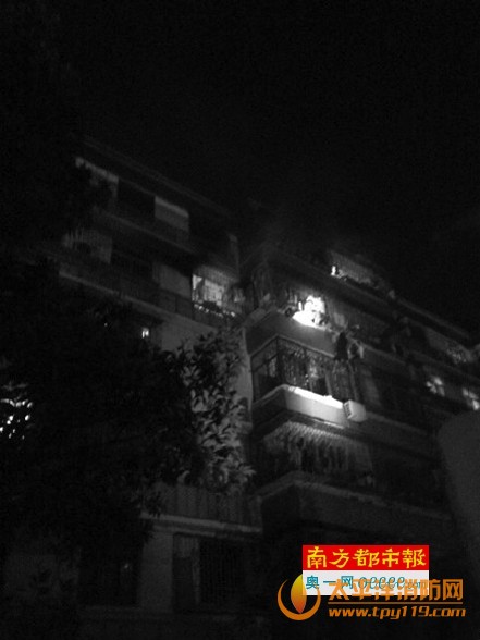 起火现场可见有人攀附在五楼阳台外，楼下住户用电筒照亮他们周边。网友拍图